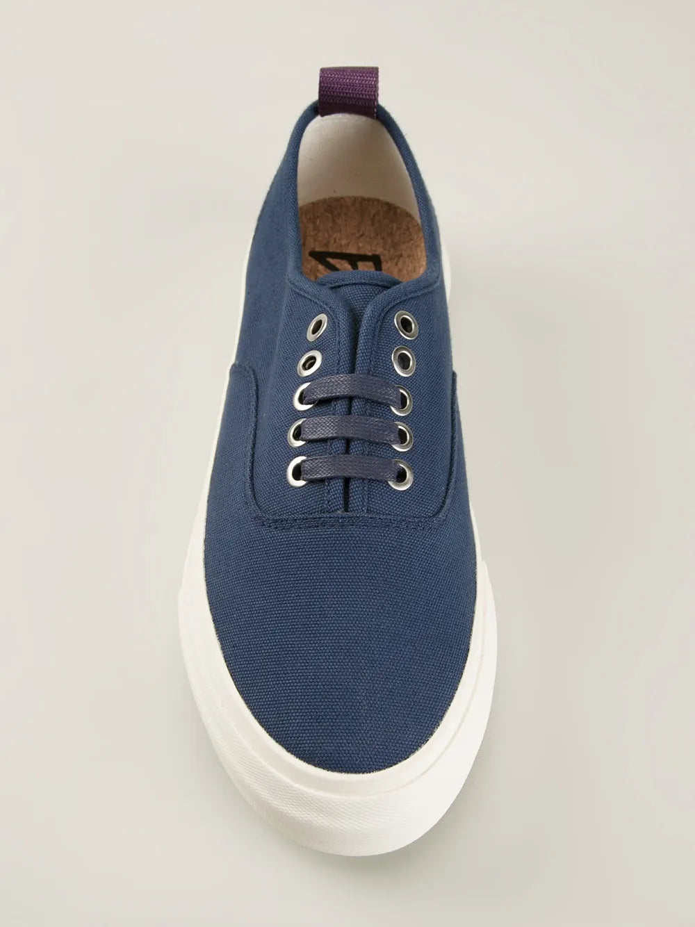 Blue canvas lace-up sneaker with white sole; tan insole and purple collar tab