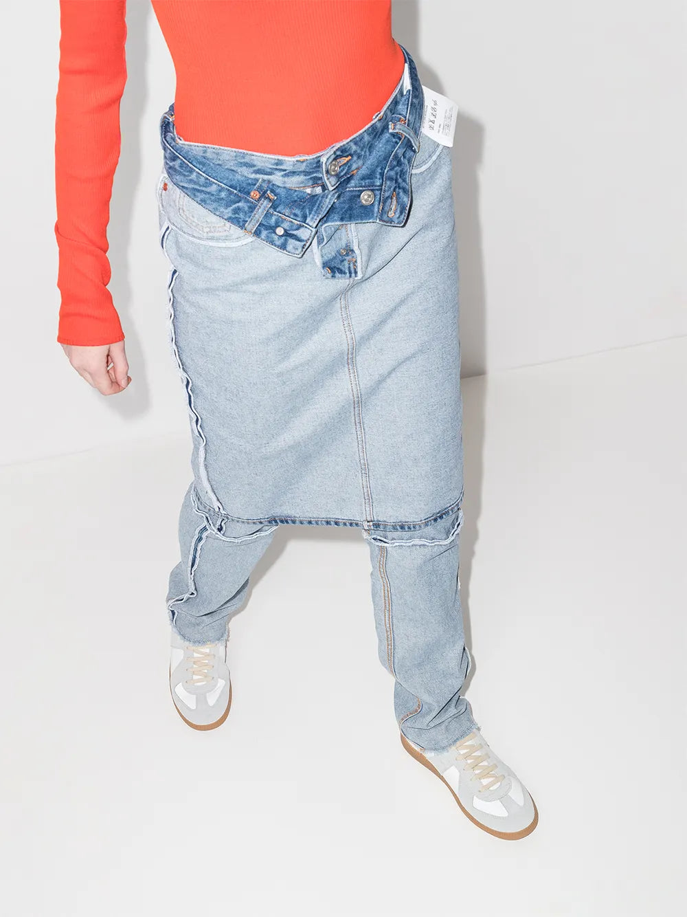 White leather low-top sneakers on feet with light blue jeans