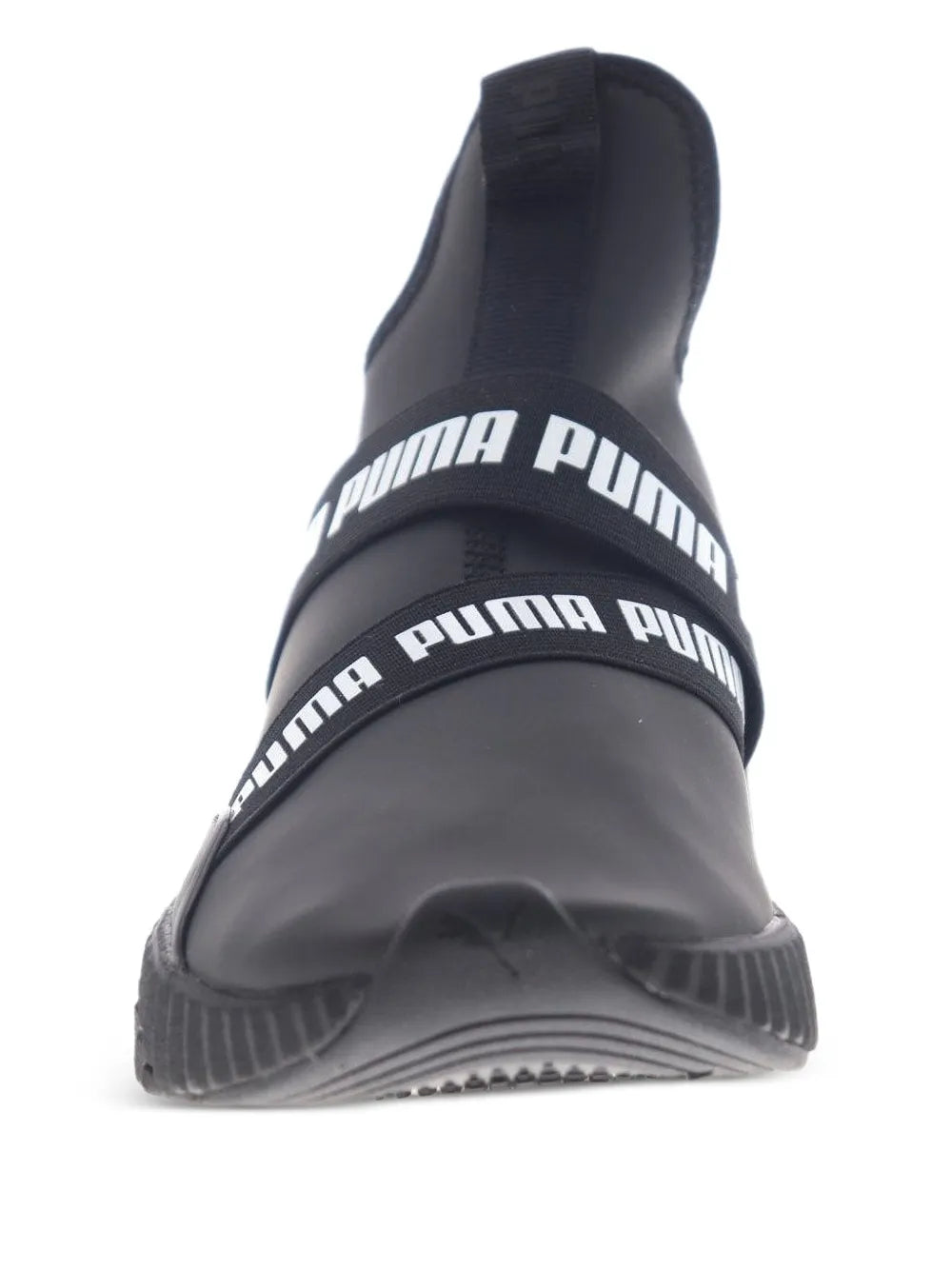 Black PUMA mid-top sneaker close-up of white logo bands and textured sole