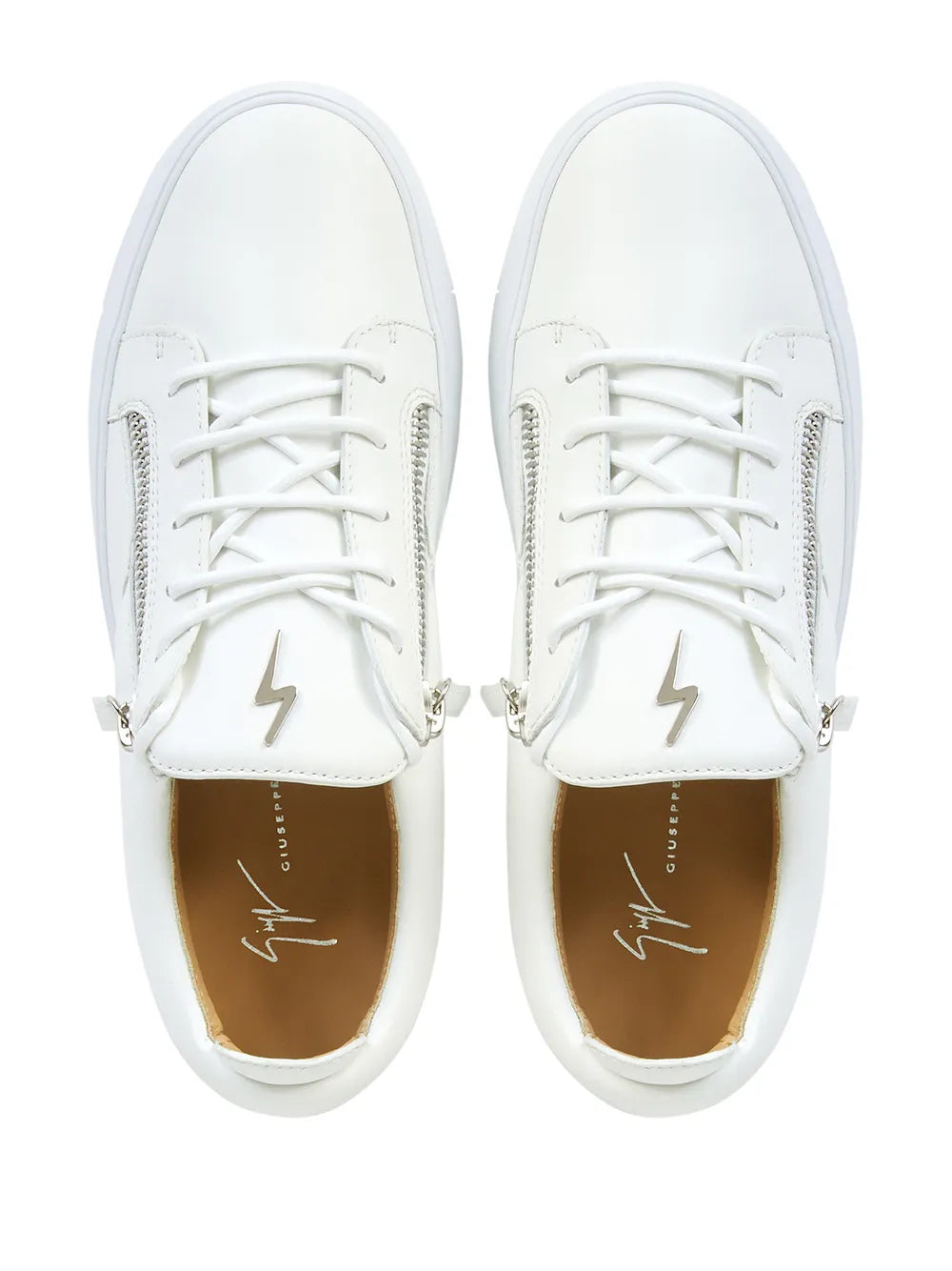 White sneakers close-up with front laces, side zipper pulls, and lightning logo on tongue