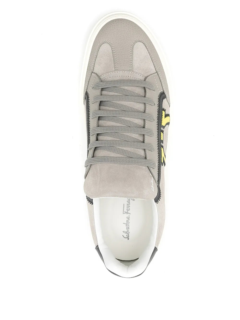 Light gray low-top sneakers front view, gray laces, yellow logo side, white sole