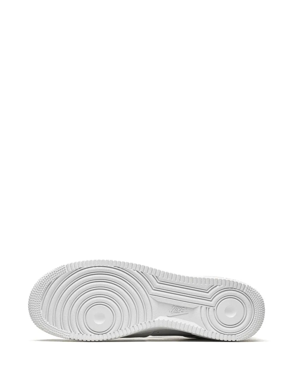 White sneaker outsole with circular traction pattern and ridged grooves