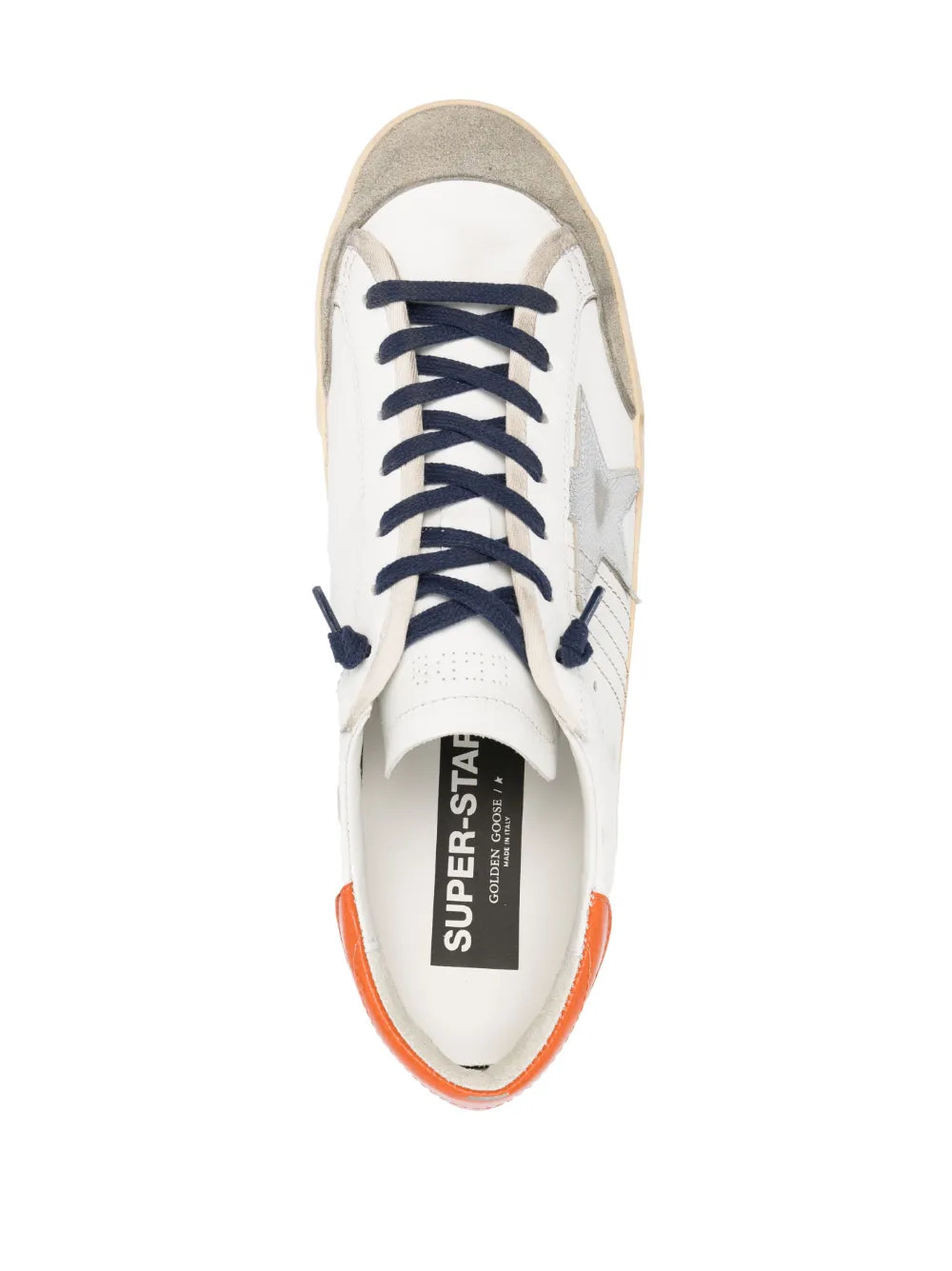 Off-white low-top sneakers with navy laces, orange trim, tongue label reading SUPER-STAR.