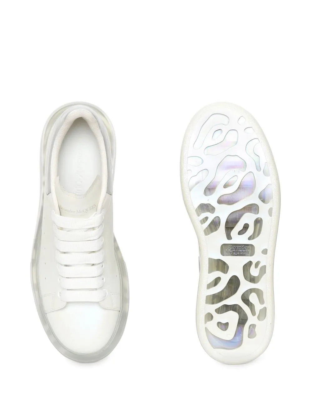 White lace-up sneakers with outsole tread visible on one shoe