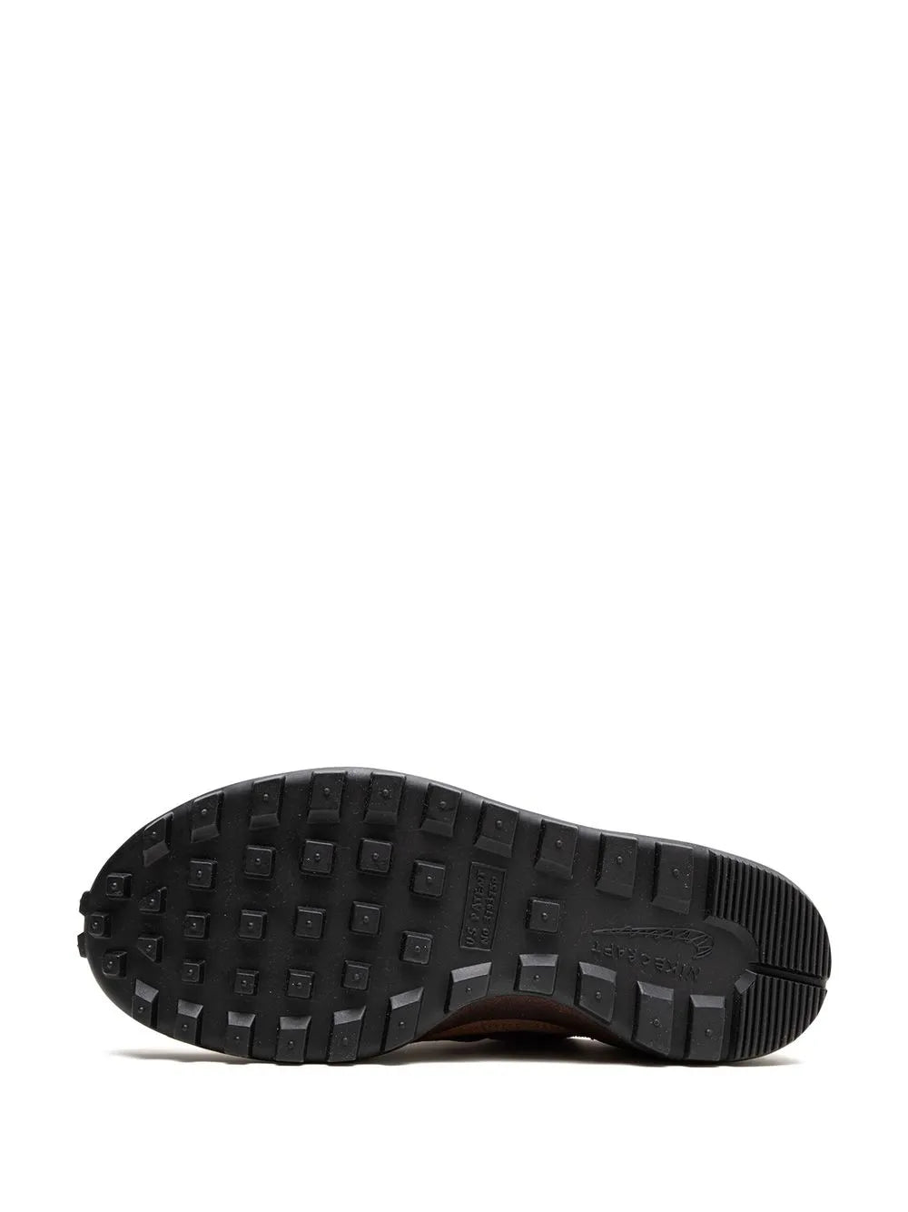 Brown sneaker outsole with black rubber tread and grippy square lugs