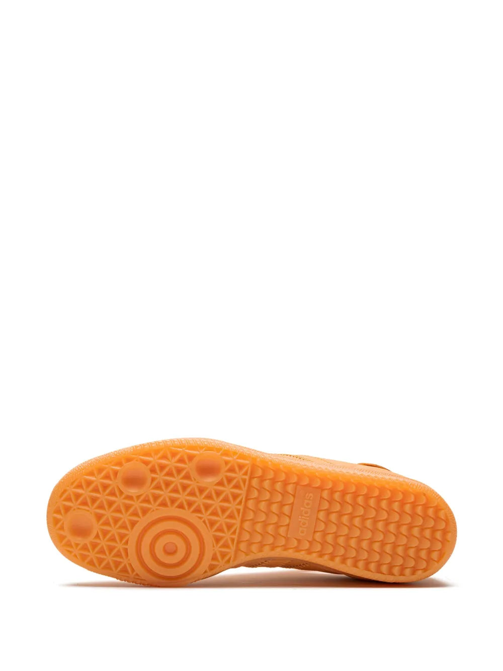 Orange rubber outsole with circular tread pattern on low-top sneakers