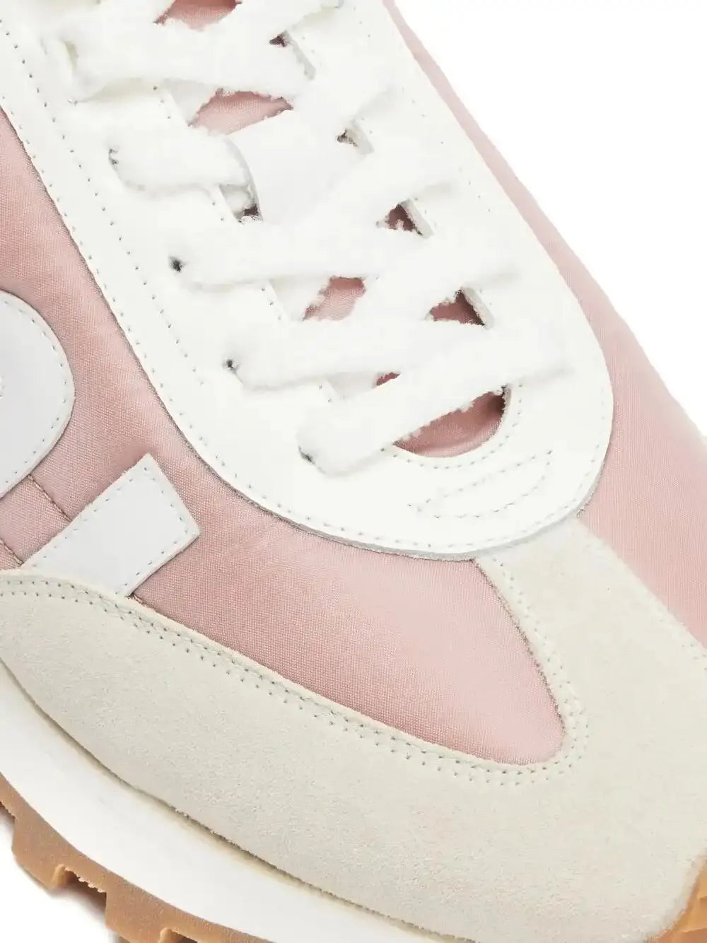 Close-up of light beige and pink sneaker with white laces and striped logo panel