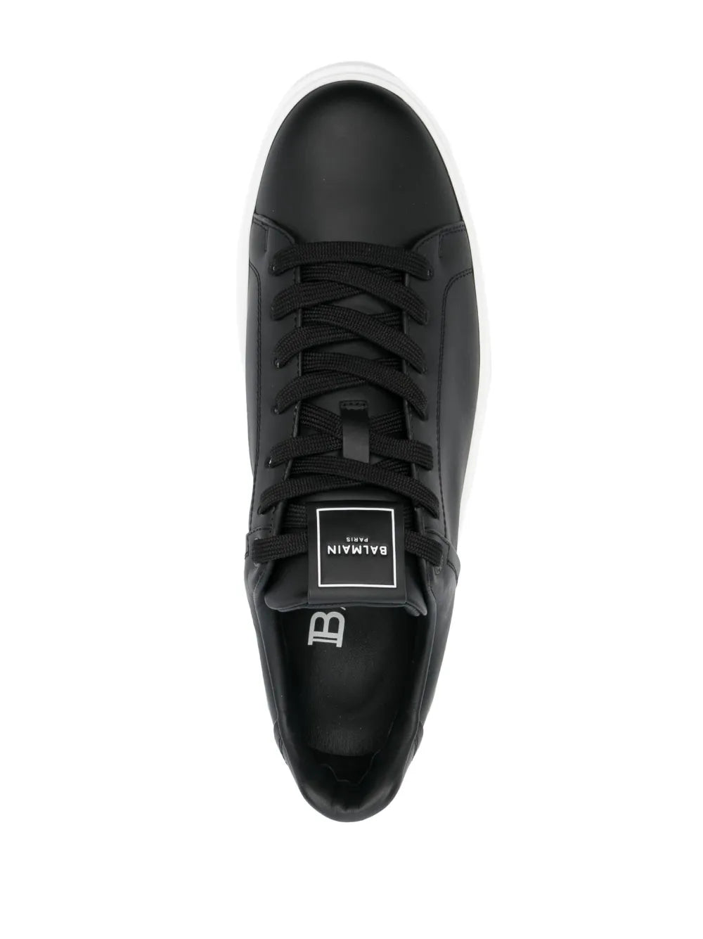Black low-top sneakers with lace-up front and logo patch on tongue
