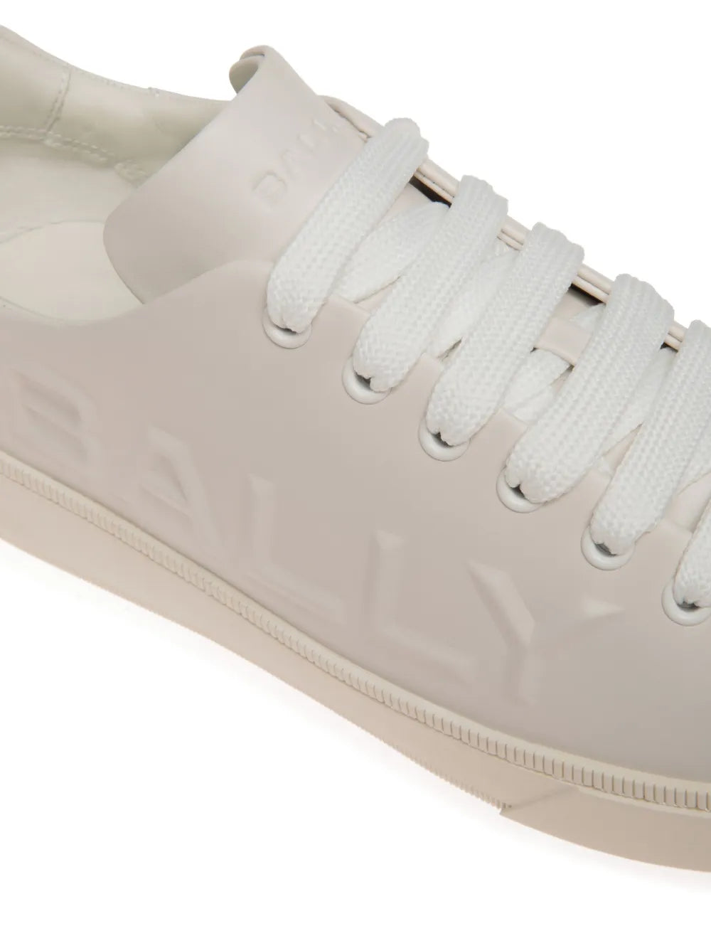 White leather trainers close-up of lace-up eyelets and Bally embossing
