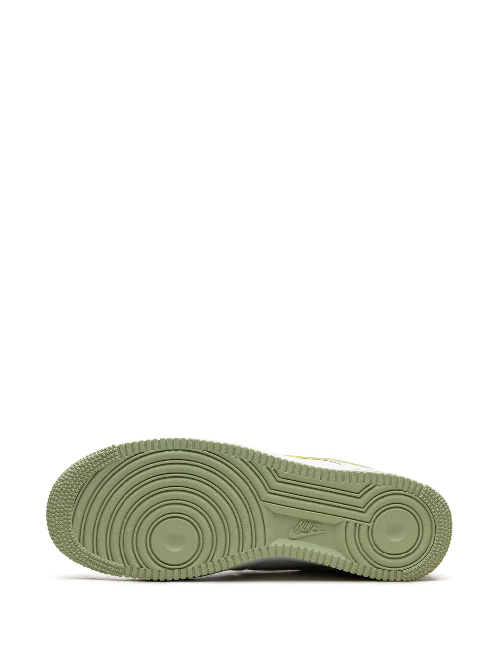 White sneaker outsole with textured tread in light green, showing circular traction pattern.