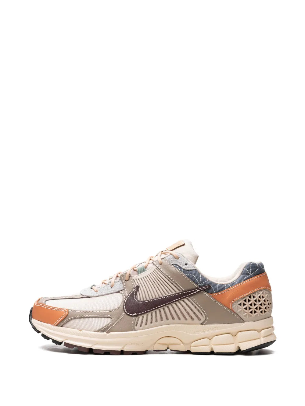 Beige Nike sneaker with orange trim and dark Swoosh, lace-up side view
