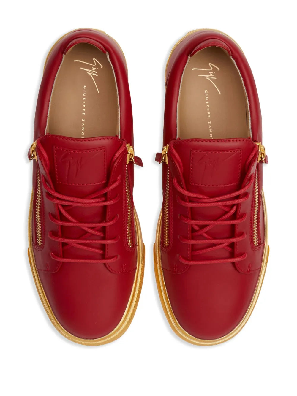 Red low-top sneakers with lace-up front, gold-tone side zippers, and yellow sole