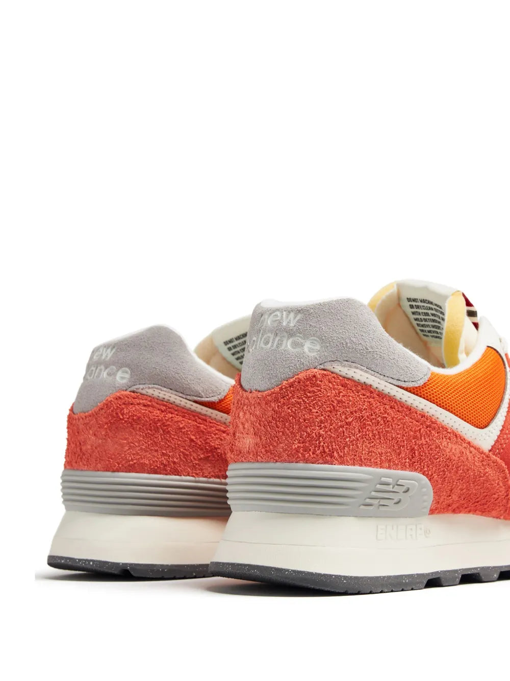 New Balance 574 suede sneakers, heel view with gray collar and orange/red suede panels