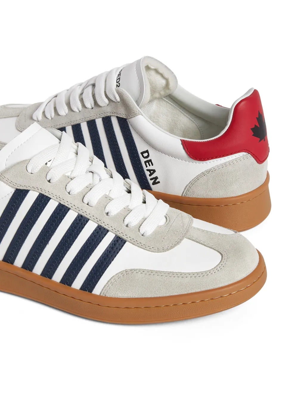 Low-top sneaker with white laces, beige suede panels, navy stripes, red heel