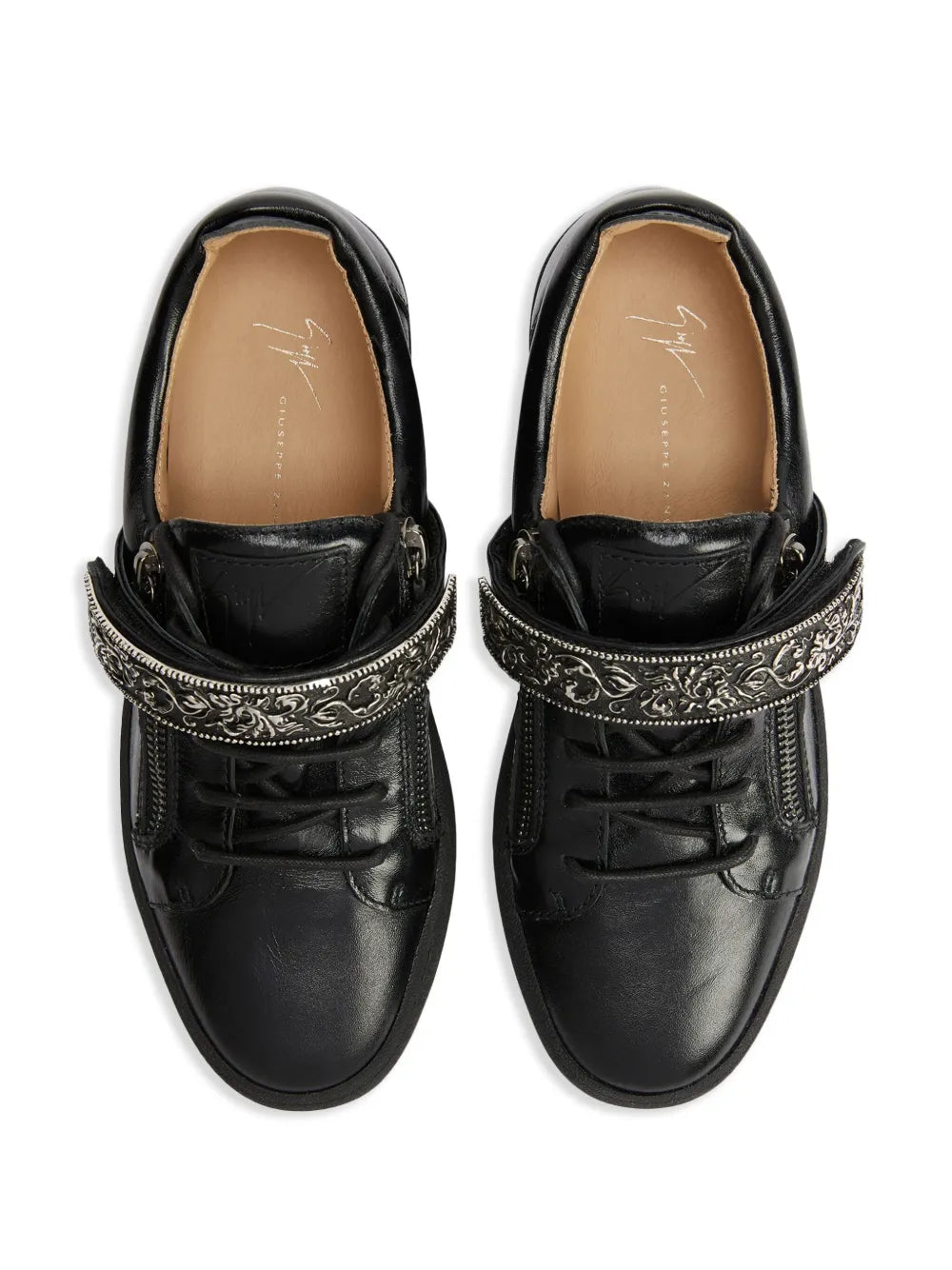 Black low-top sneakers, top view showing tan insoles and ornate zipper trim