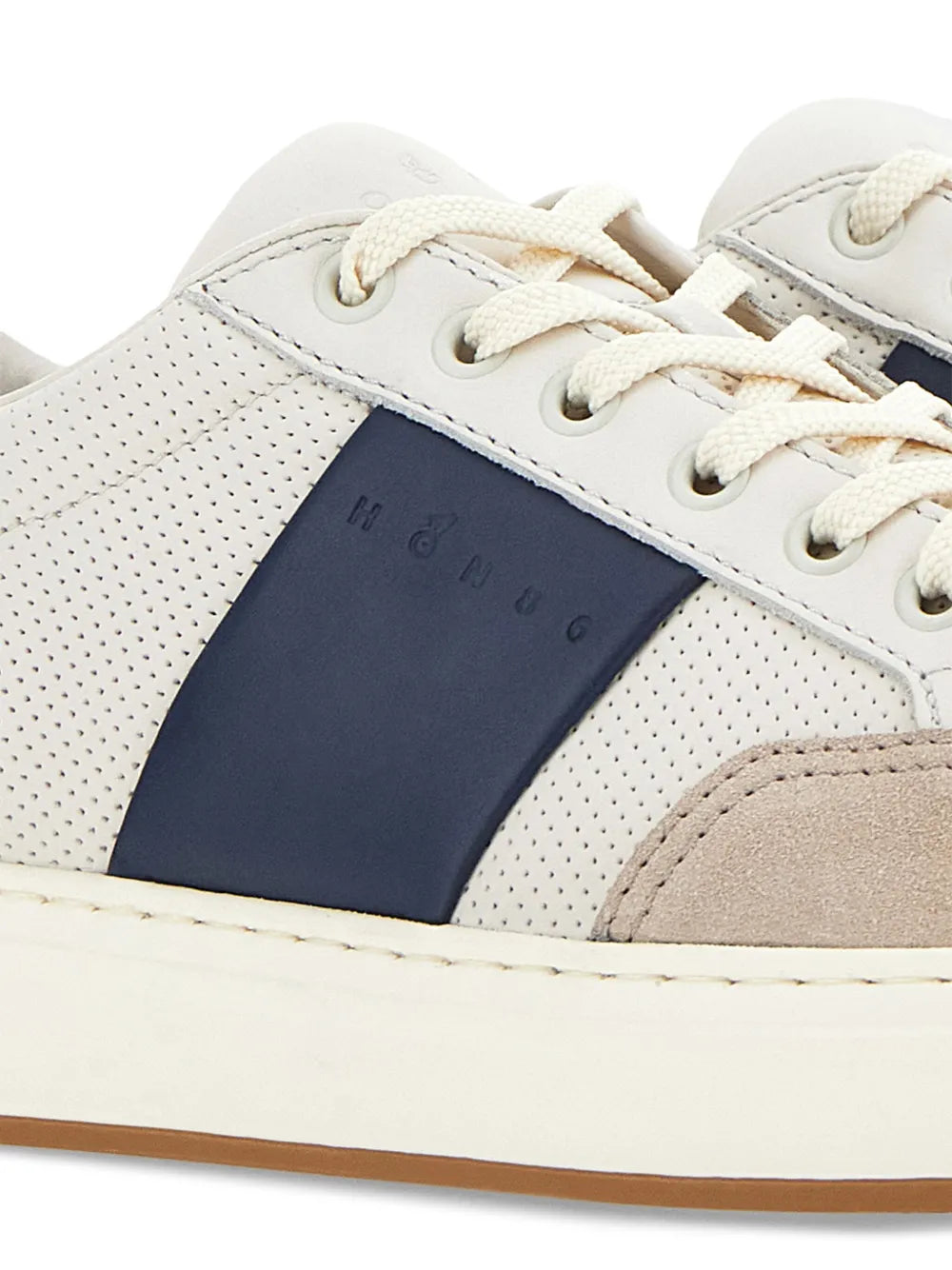 Hogan logo trainers close-up: perforated leather, navy stripe, cream laces and stitching