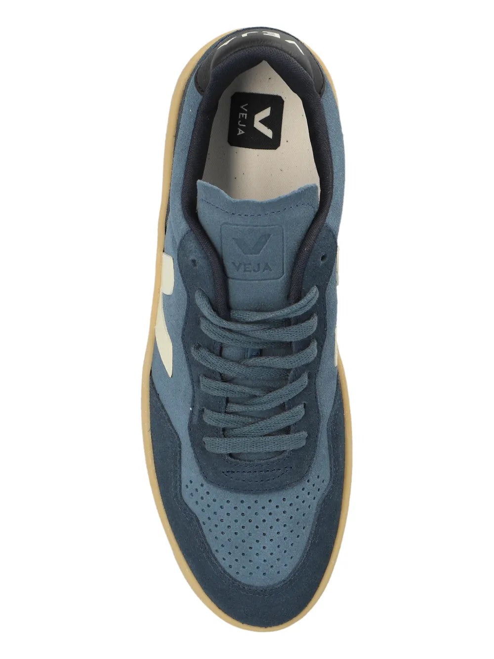 Blue suede sneaker upper close-up with white V logo and lace-up front