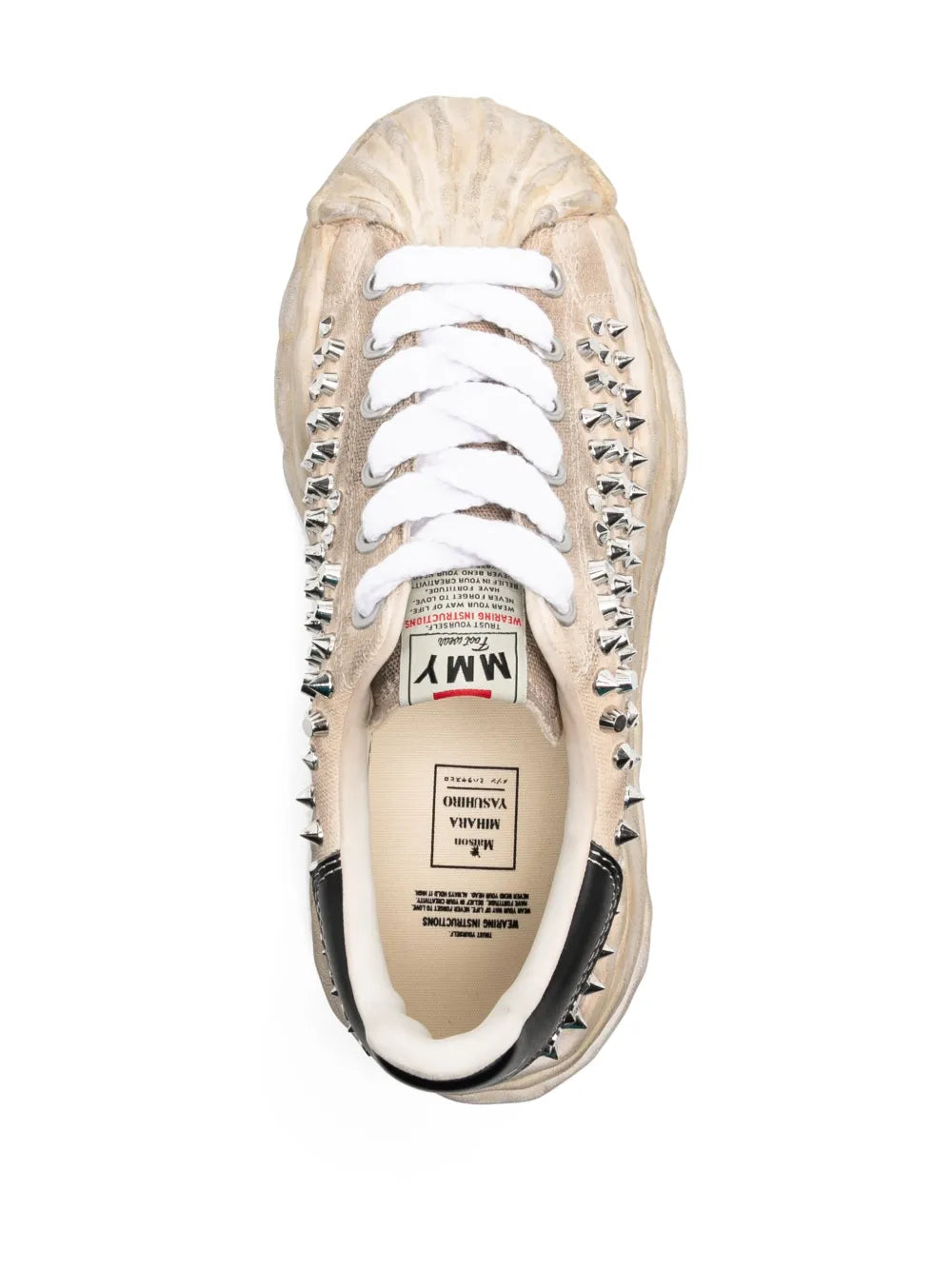 Beige sneaker with white laces, black-trim opening, interior brand label