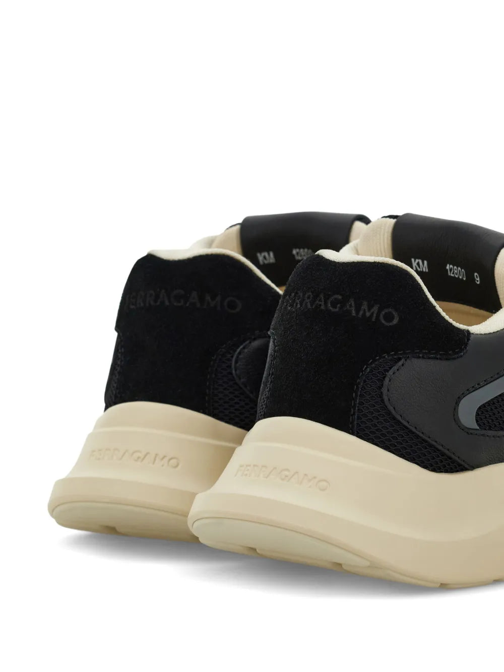 Black Gancini sneakers with cream heel tab and chunky beige rubber sole.