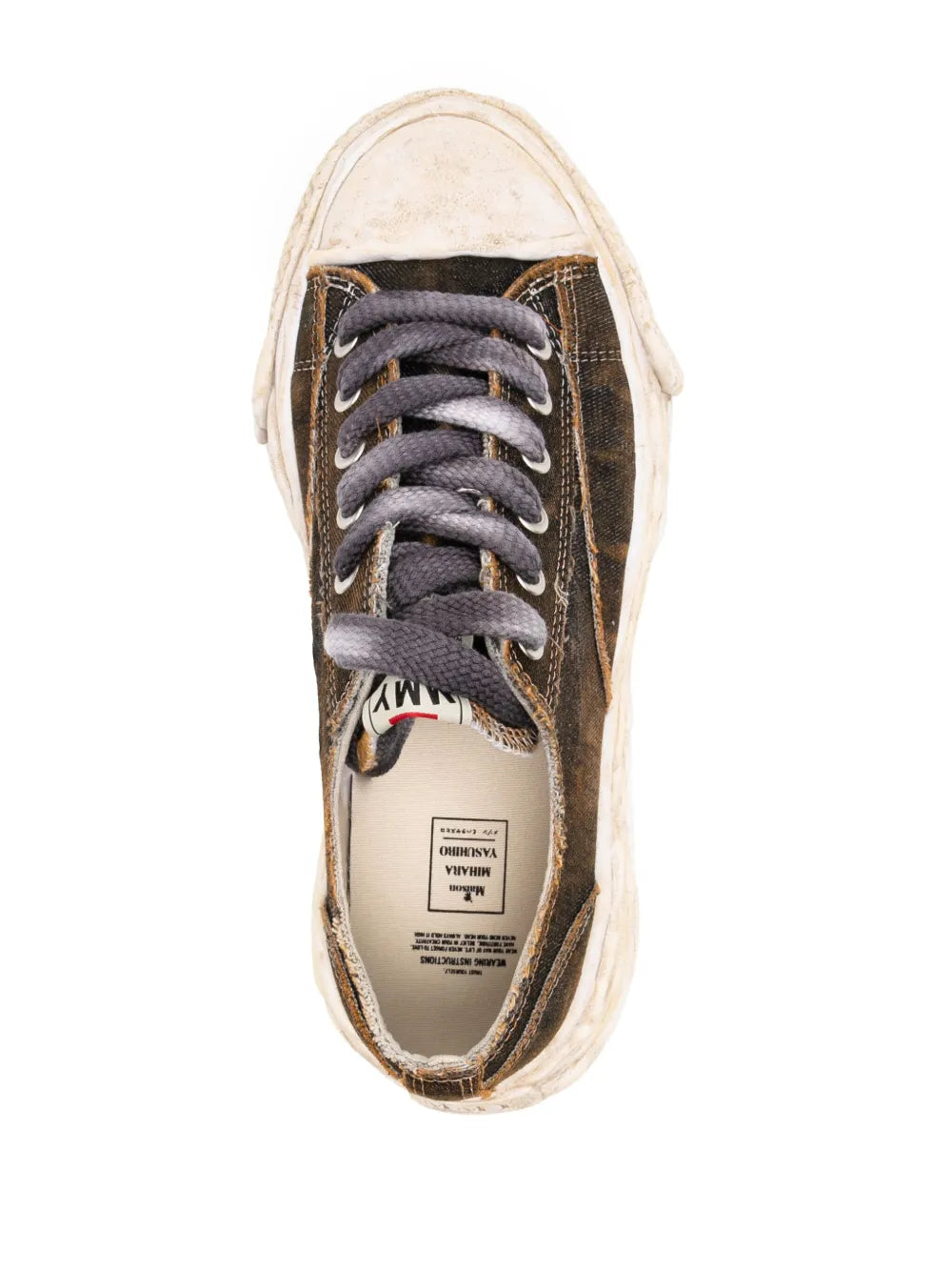 Low-top sneaker inside view, lace-up tongue label and cream rubber sole