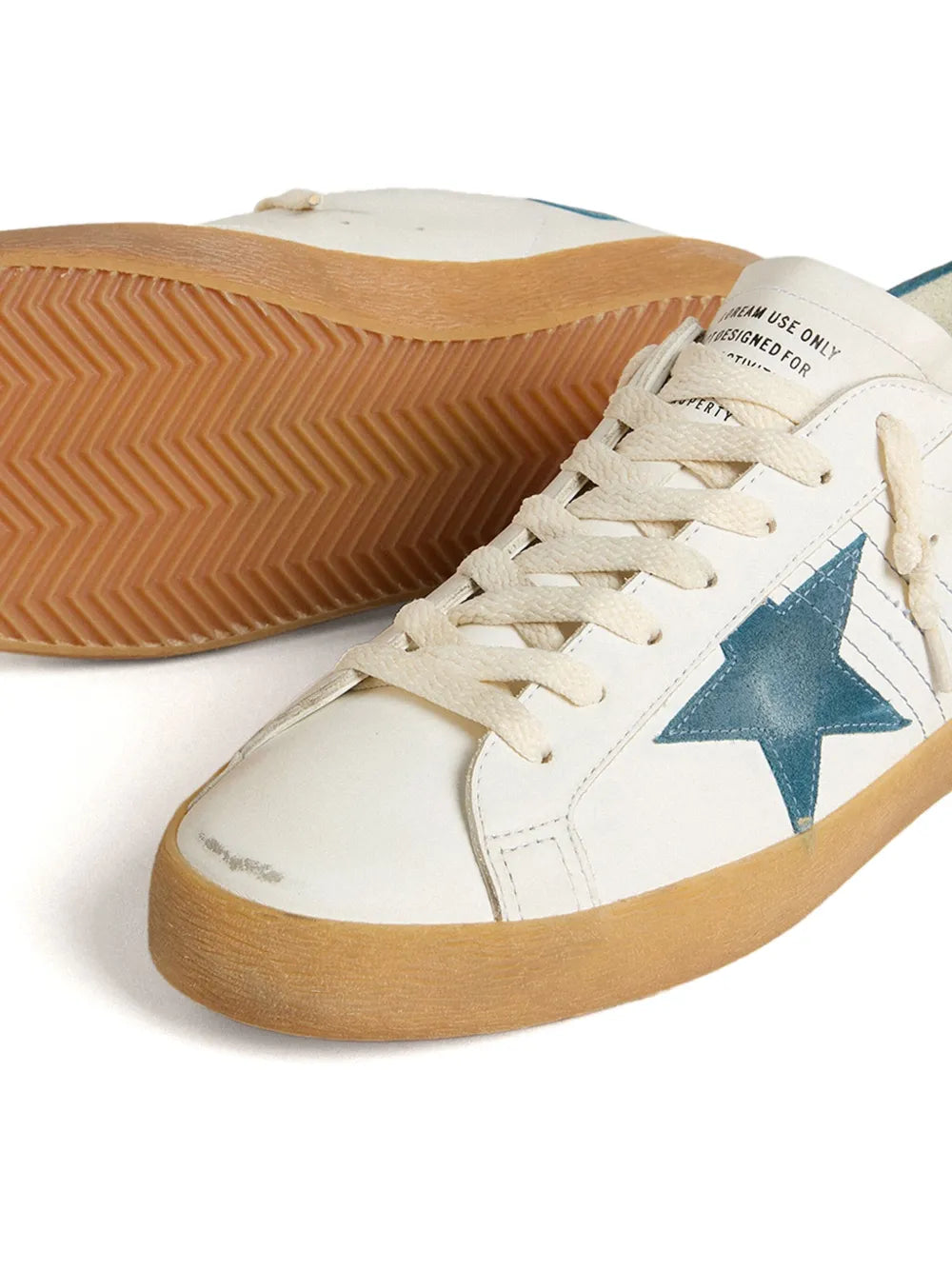 Golden Goose Super Star sneakers close-up, white leather, blue star, textured gum sole
