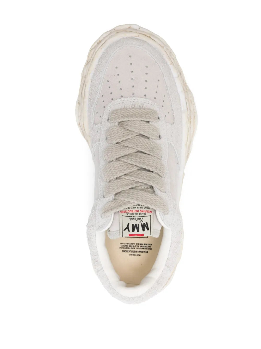 White sneaker upper close-up with perforated toe and lace eyelets