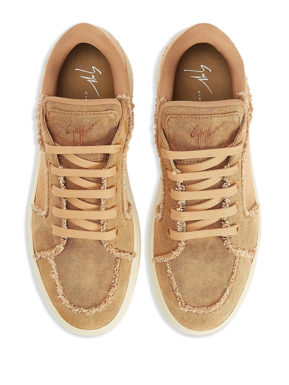 Pair of light brown lace-up low-top sneakers with frayed edges and cream soles