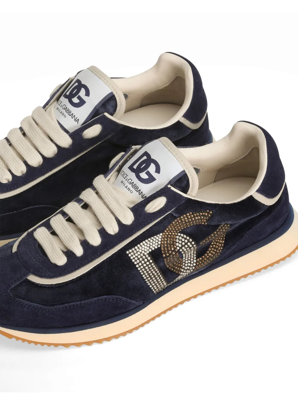 Close-up of dark blue sneakers with glittery DG logo and cream laces