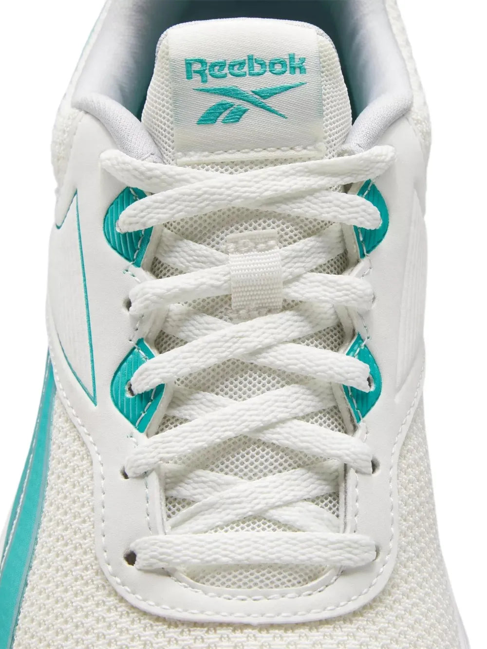 Light beige sneaker close-up with teal Reebok logo, white laces, and knit upper