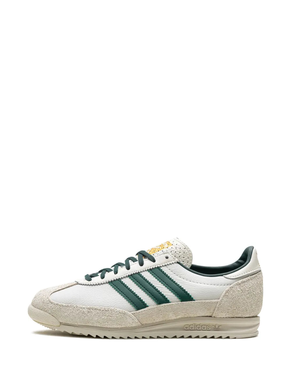 Off-white low-top adidas sneakers with green stripes and dark lace-up upper
