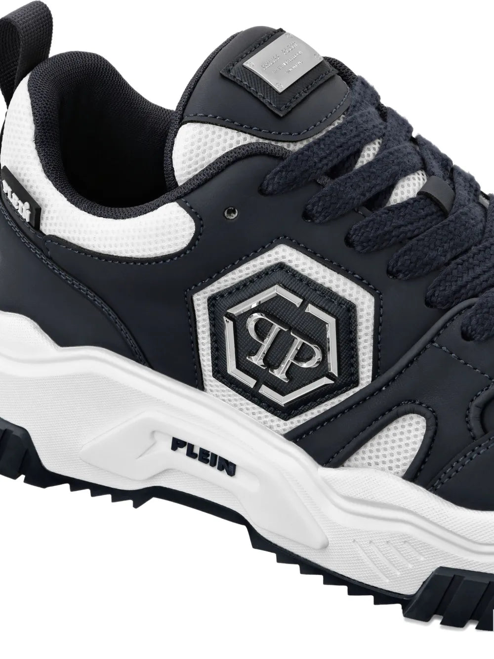 Dark navy and white lace-up sneaker with front logo patch and chunky tread sole