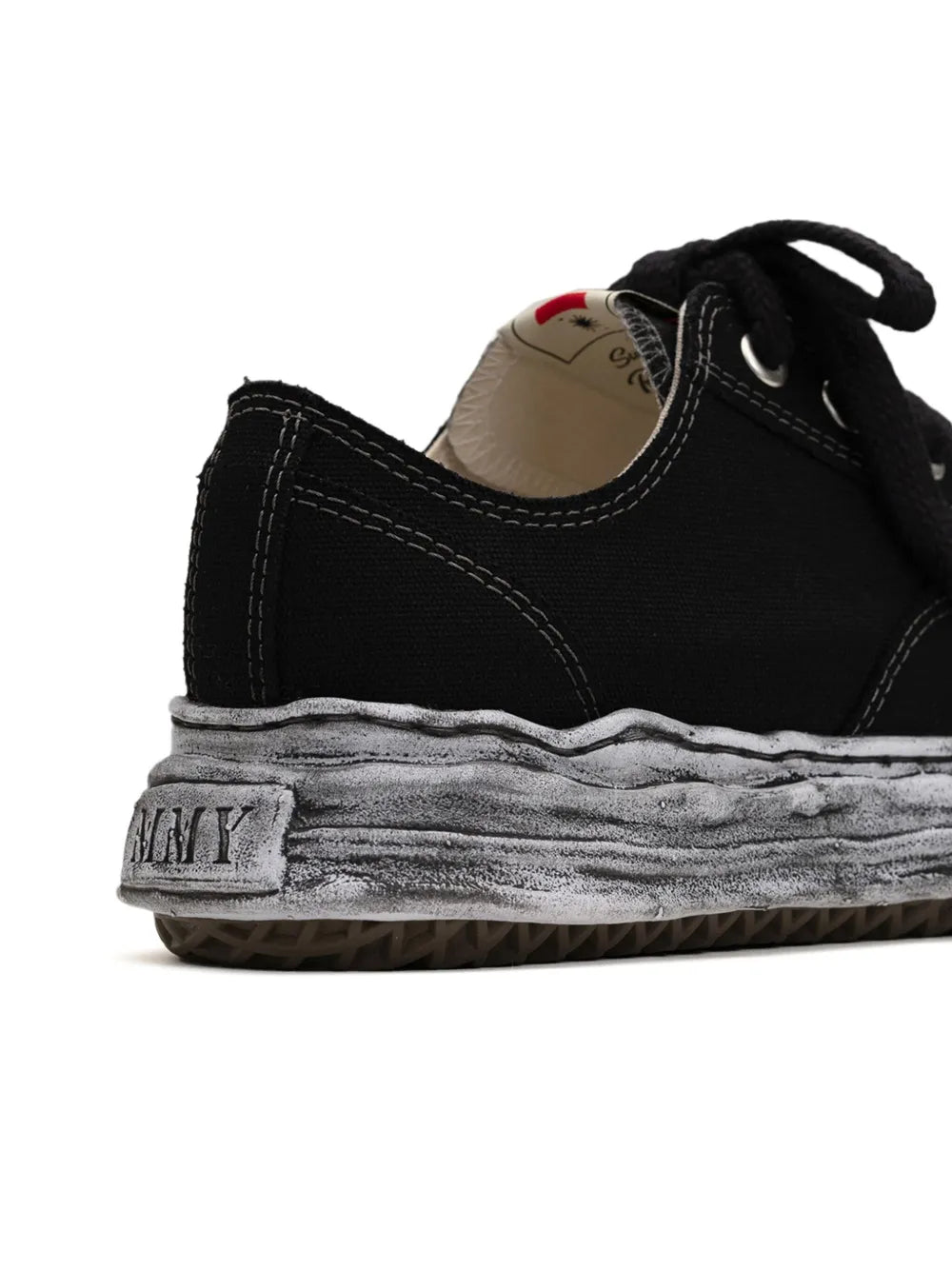 Black low-top sneaker heel with tan lining and distressed gray sole