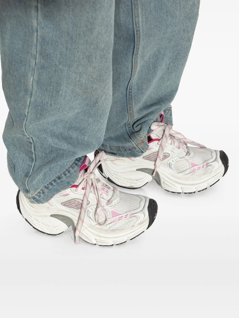 Balenciaga 6XL white and pink sneakers on feet with light-wash jeans and lace-up front