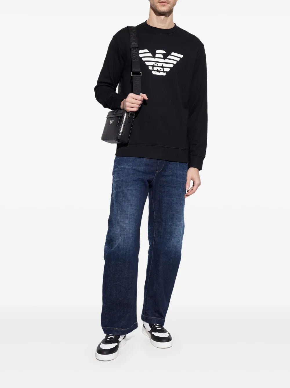 Low-top sneakers on model, white-and-black lace-up shoes with chunky sole.