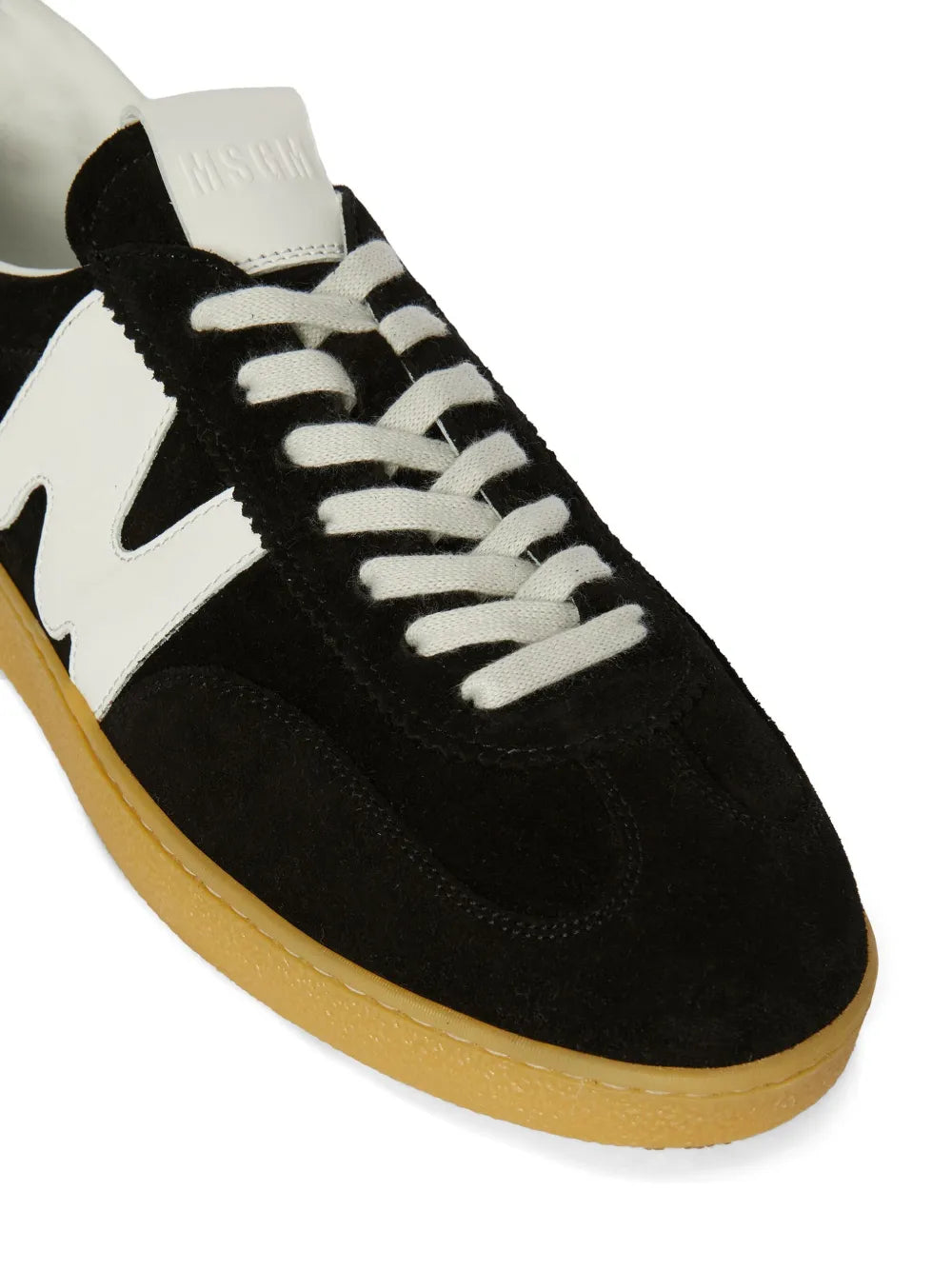 Black suede sneaker with white logo insert, lace-up front, tan gum sole