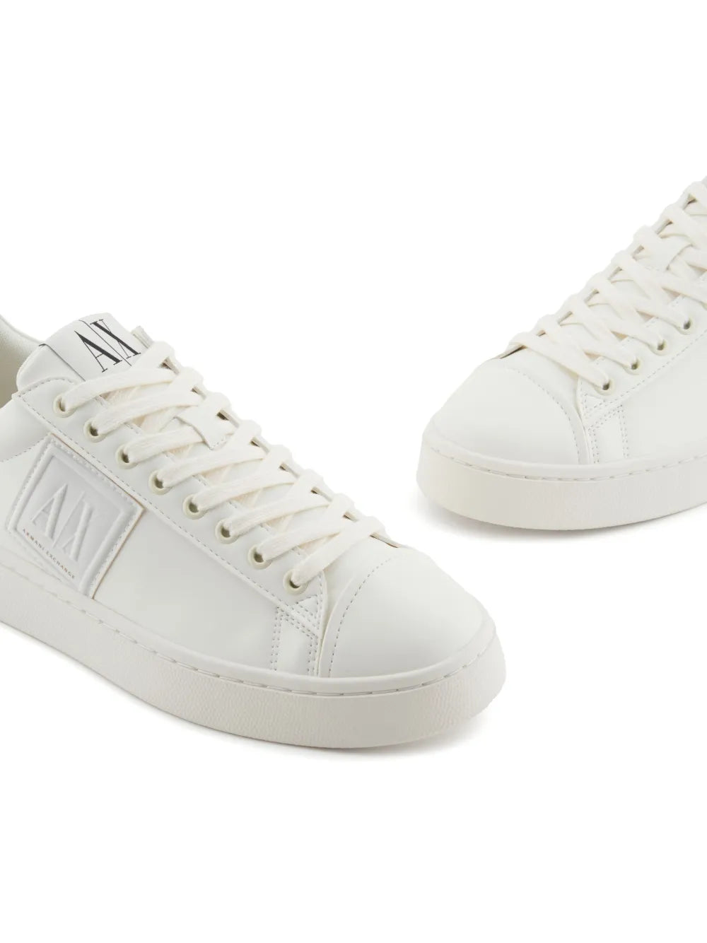 White Armani Exchange logo trainers, angled side view with stitched panels
