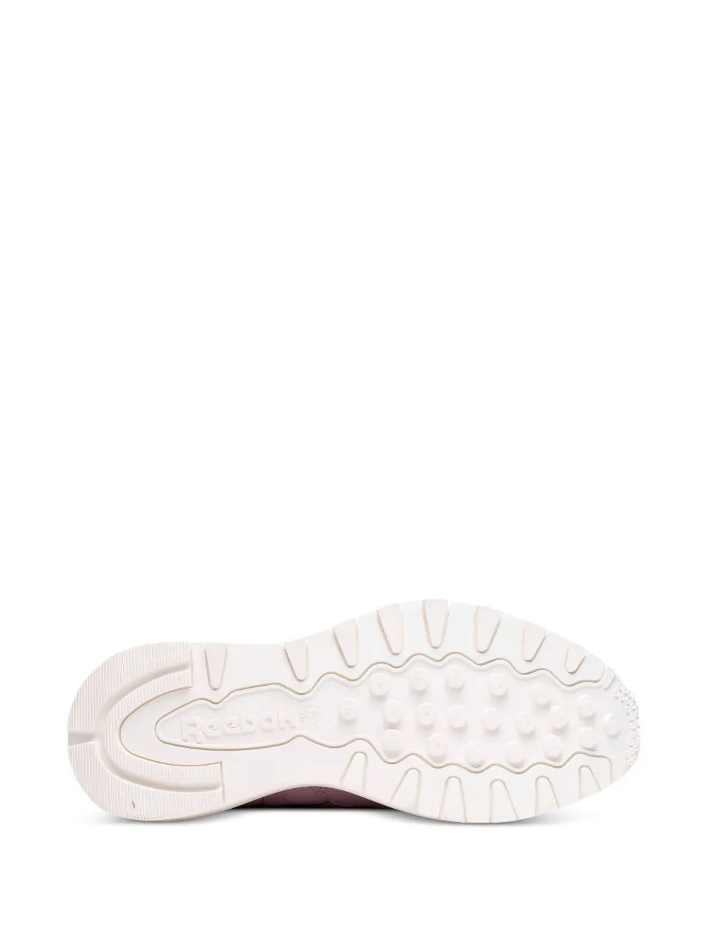 Pink and white sneaker outsole with tread pattern and Reebok branding