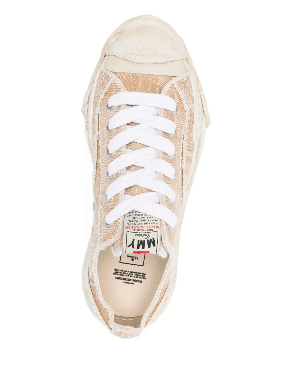 Beige canvas low-top sneakers showing lace-up tongue and interior label
