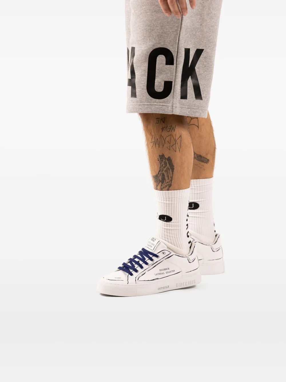White sneakers with navy-blue laces and printed side text on model