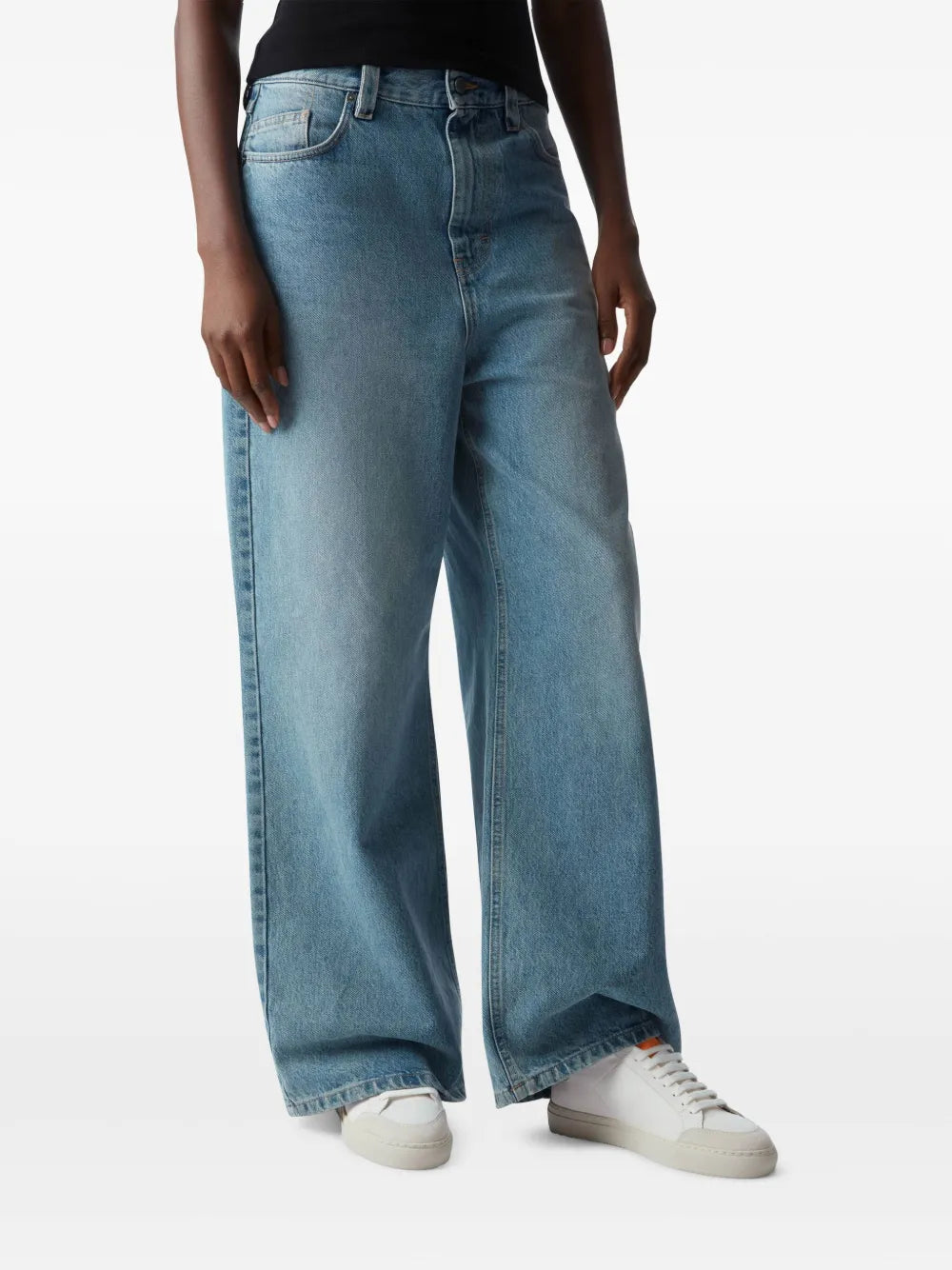 White lace-up sneakers worn with blue jeans