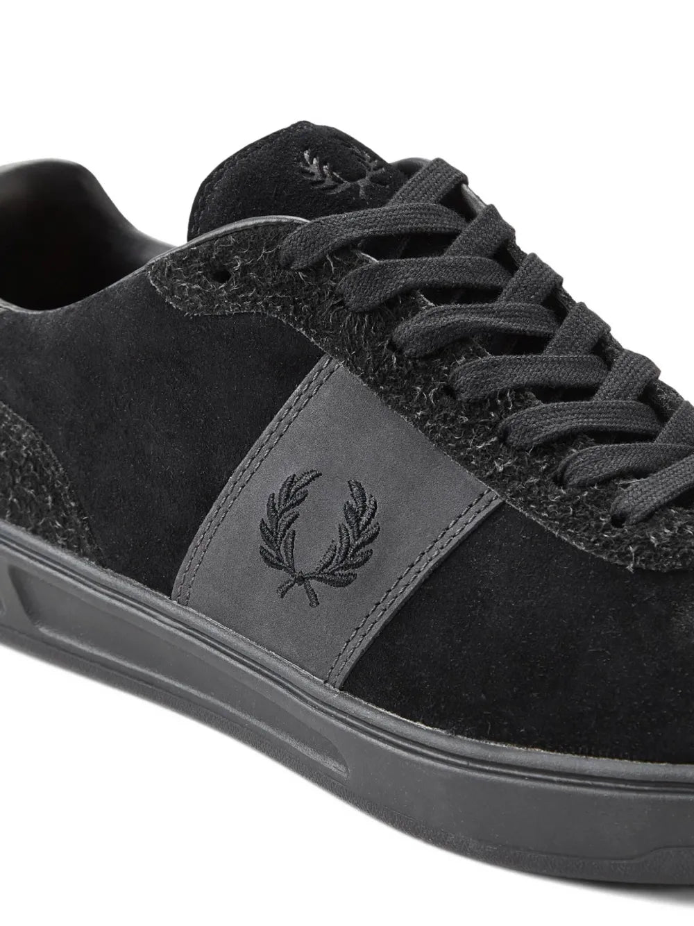 Black Fred Perry sneakers close-up: embroidered laurel logo on side panel