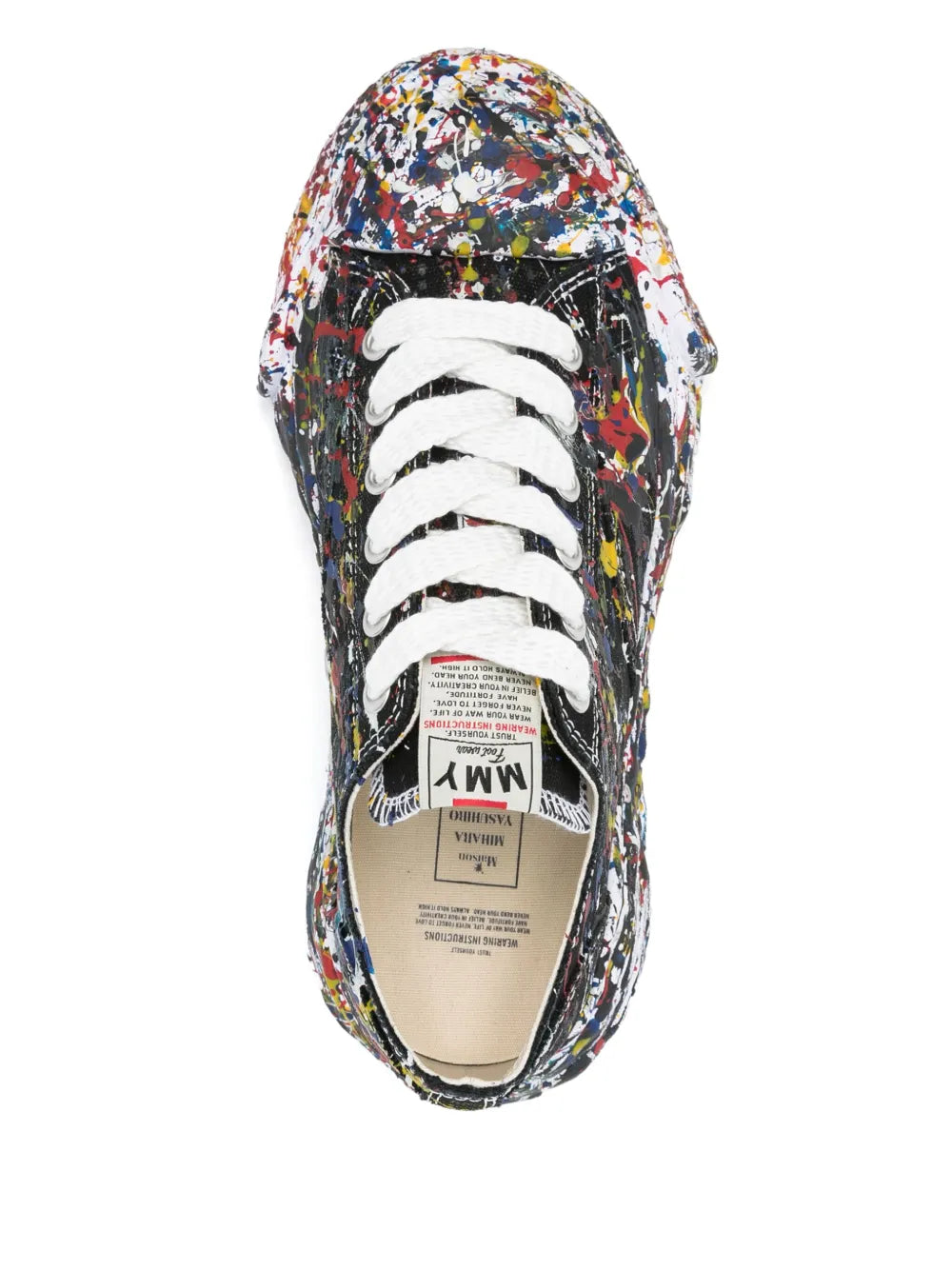 Black low-top sneaker with paint-splatter upper, white lace-up, tongue label
