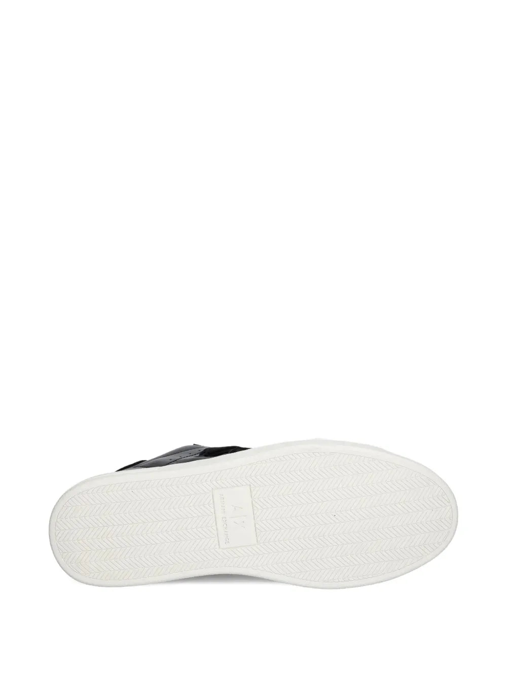 Black sneakers with white outsole, textured tread bottom view