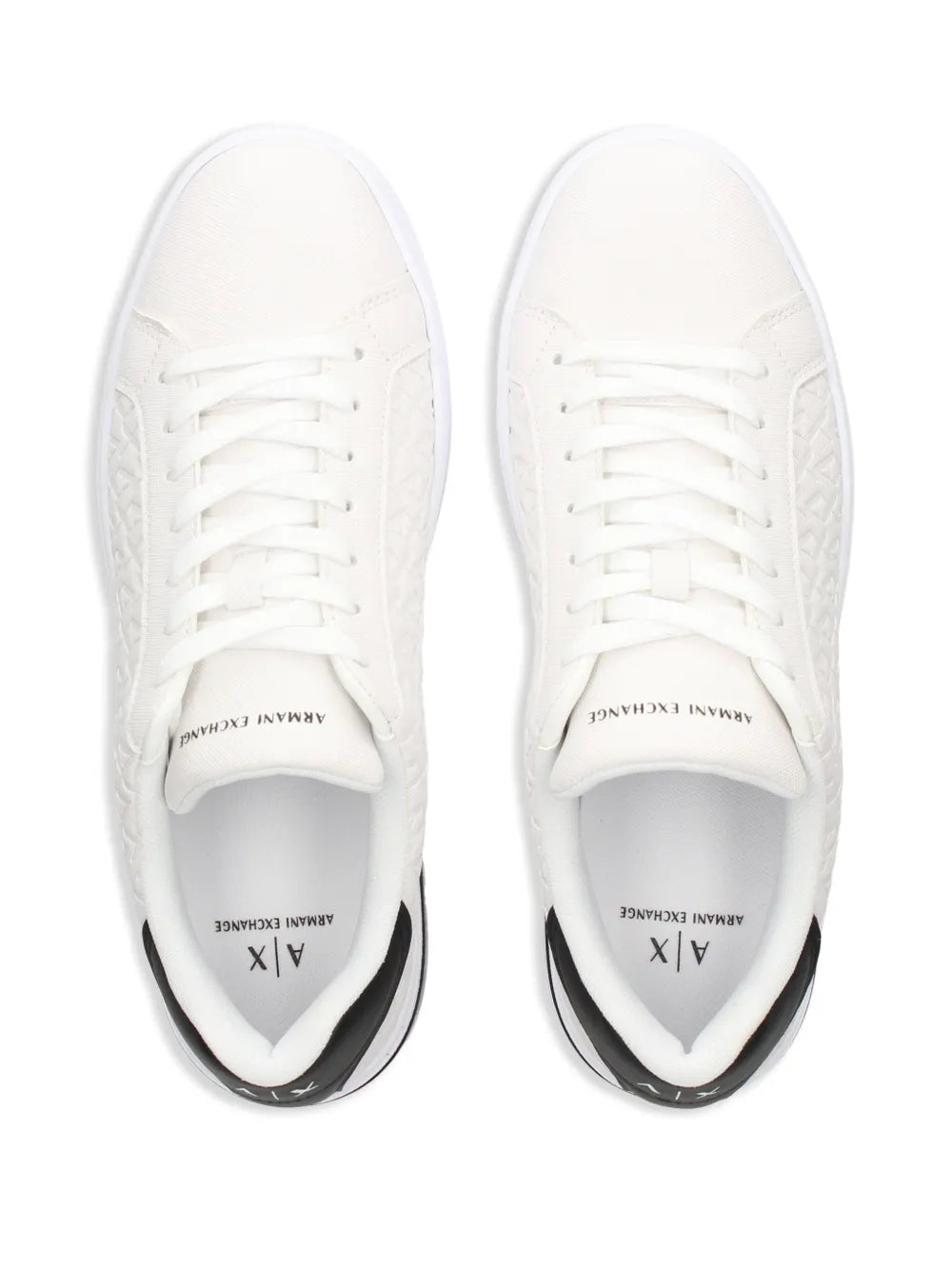 Pair of white quilted sneakers with white laces and rubber bumper sole