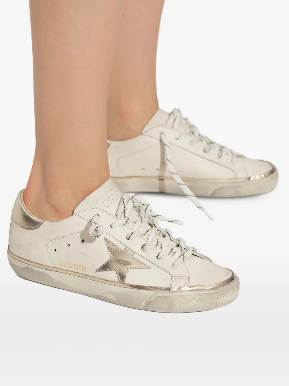 Beige sneakers with star patch, white laces, and textured rubber sole