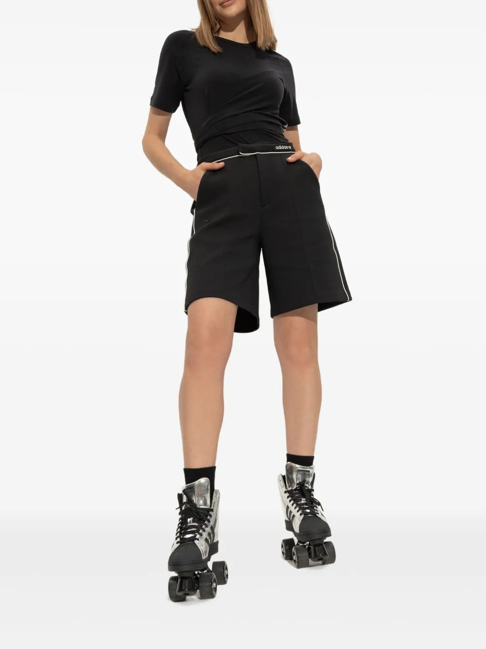 adidas Superstar roller skates, full look on skater with black shorts and silver high-tops