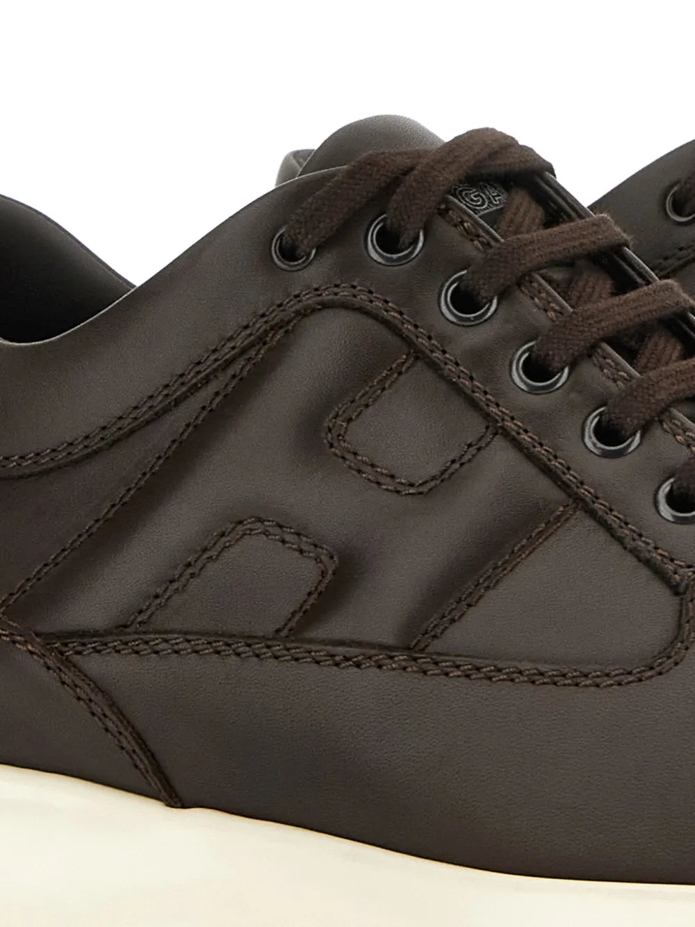 Hogan interactive sneakers close-up: dark brown upper with lace eyelets and stitched panels