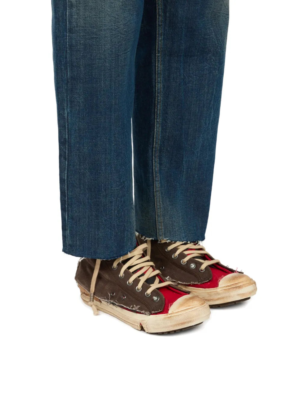 Brown high-top sneakers with red accents worn with blue jeans, beige lace-up