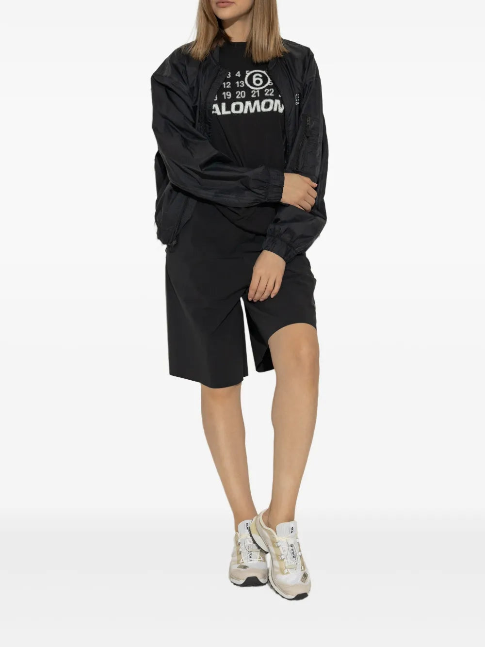 Beige Salomon-style sneaker mule worn with black shorts, lace-up front
