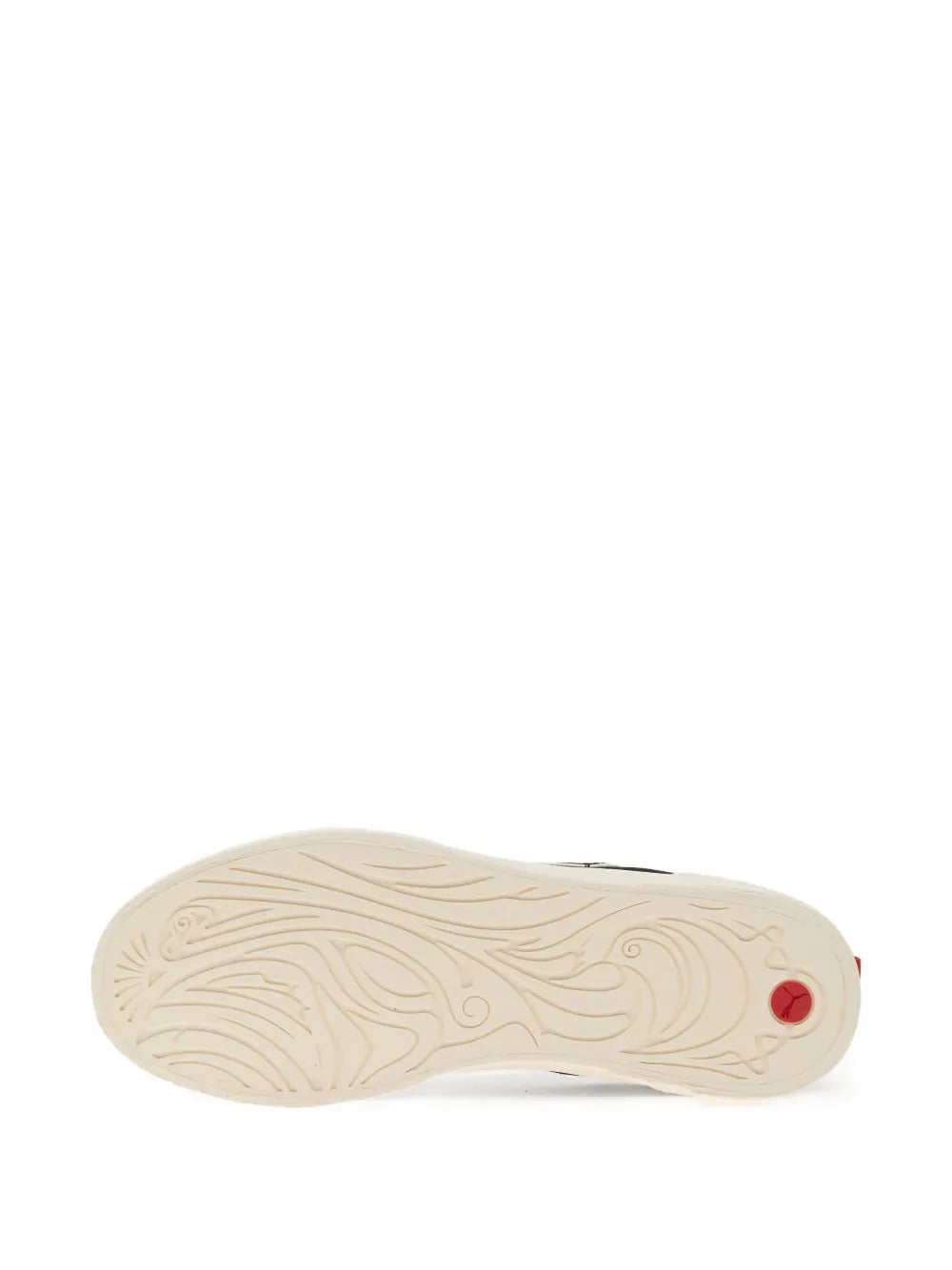 Cream outsole of black PUMA lace-up sneakers with textured traction and red detail